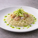 Risotto al parmigiano all’onda con aringa affumicata, julienne di mela verde e olio all’erba cipollina