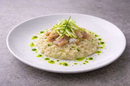 Risotto al parmigiano all’onda con aringa affumicata, julienne di mela verde e olio all’erba cipollina