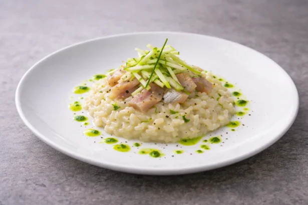 Risotto al parmigiano all’onda con aringa affumicata, julienne di mela verde e olio all’erba cipollina